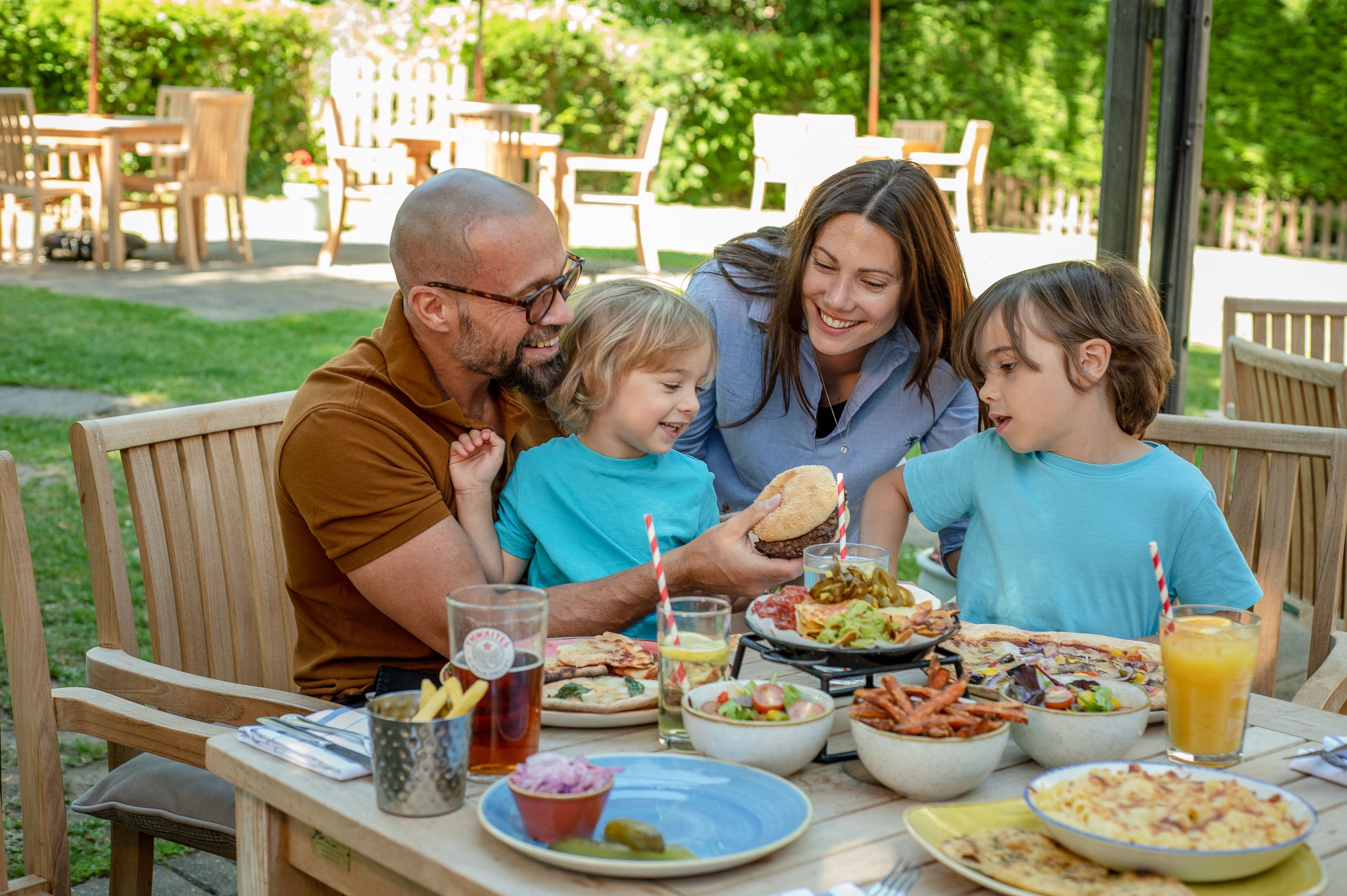 Family of four enjoying a burger outside